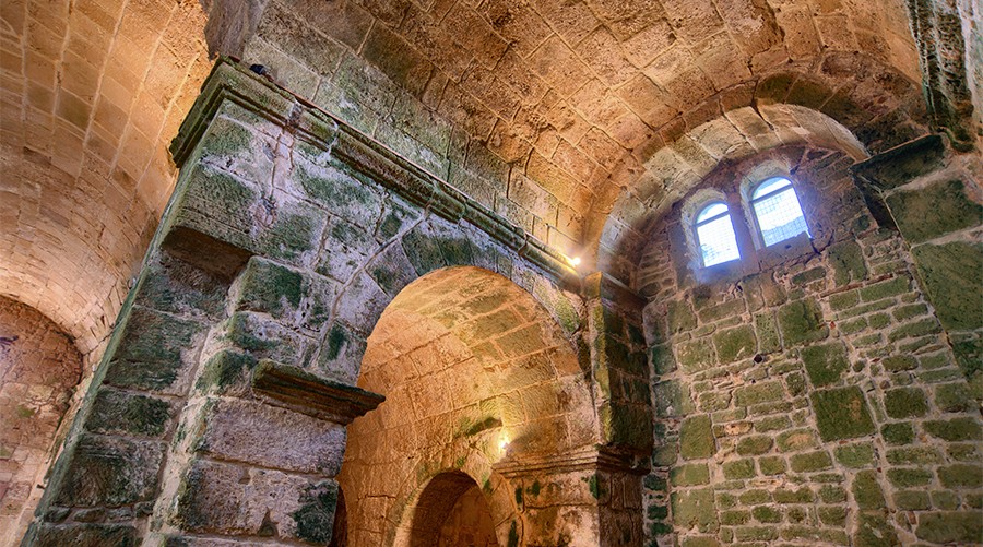 Sandstone interior walls and vaulted ceiling of the church of San Giovanni in Tharros.
